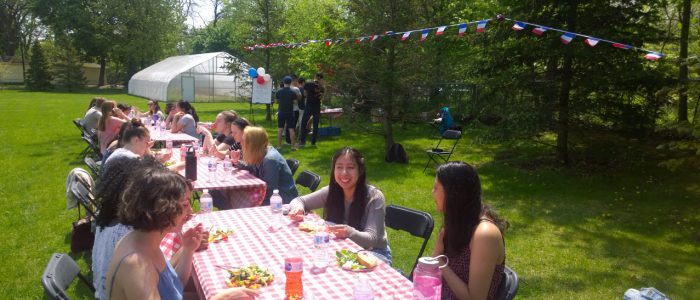 Students enjoing the French Day lunch while eating at picnic tables.